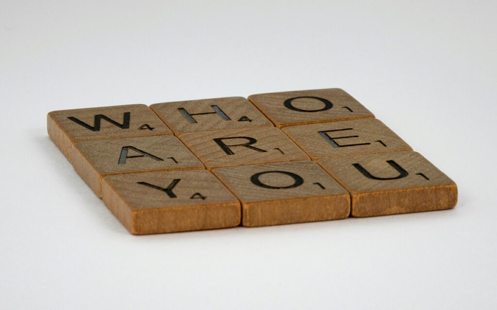 scrabble pieces display the words who are you